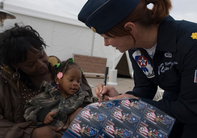 Tianna Morgan holds her niece Shannice Searles while Maj. Kristin Haley, U.S. Air Demonstration Squadron public affairs officer, gives her an autographed photo during the 2011 Aviation Nation Open House Nov. 11, at Nellis Air Force Base, Nev. Aviation Nation celebrates 70 years of airpower in Las Vegas and the Air Force's accomplishments in air, space and cyberspace.  (U.S. Air Force photo by Senior Airman Stephanie Rubi/Released)