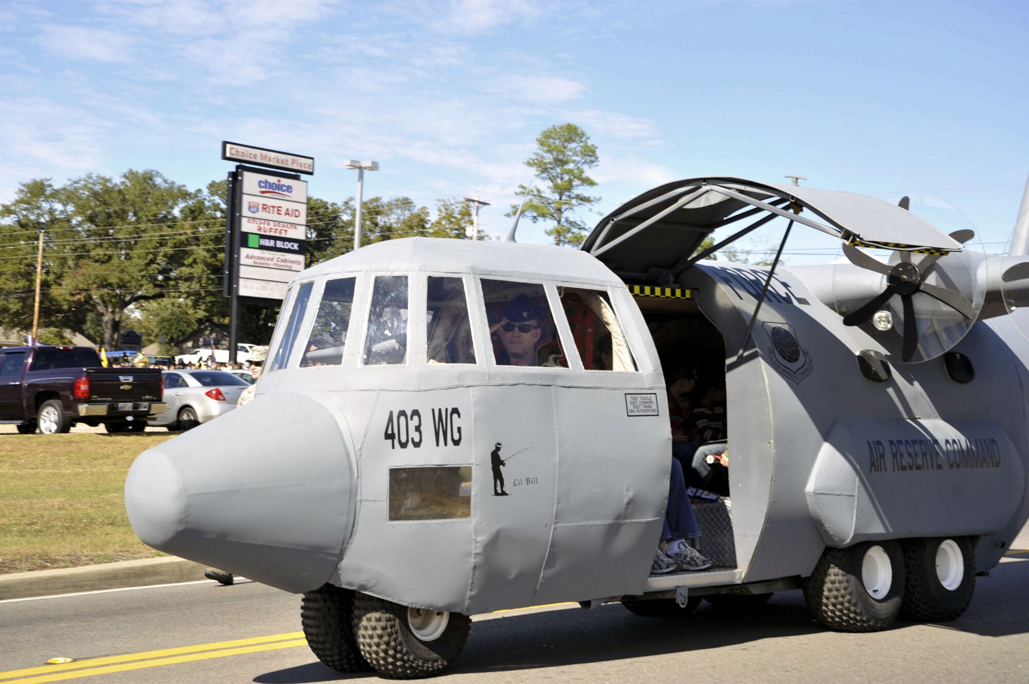 Col. Jay Jensen, 403rd Wing commander, salutes the crowd as he pilots Lil' Bill in the Gulf Coast Veterans Day Parade Nov. 12. Lil' Bill is a scale model of the 403rd Wing's C-130J aircraft and is used by the 403rd's Recruiting Squadron during community and recruiting events.(U.S. Air Force photo by Maj. Heather Newcomb)