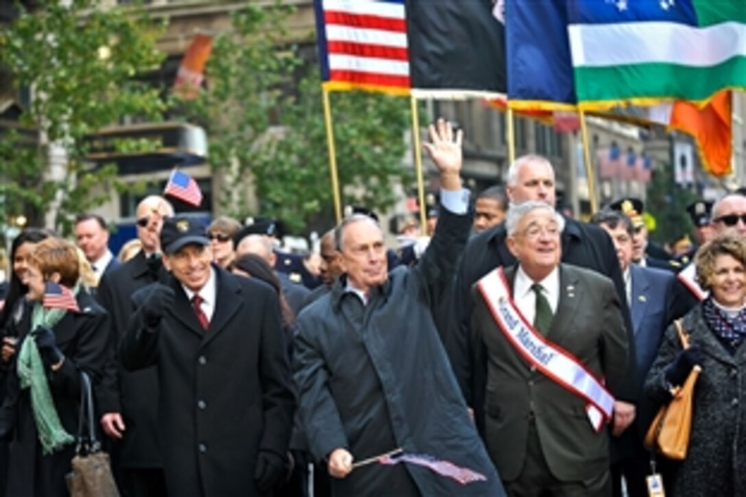 New York Mayor Michael Bloomberg, center, and retired Army Gen. David H. Petraeus, director of the CIA, salute a crowd during the Veterans Day Parade in New York, Nov. 11, 2011.