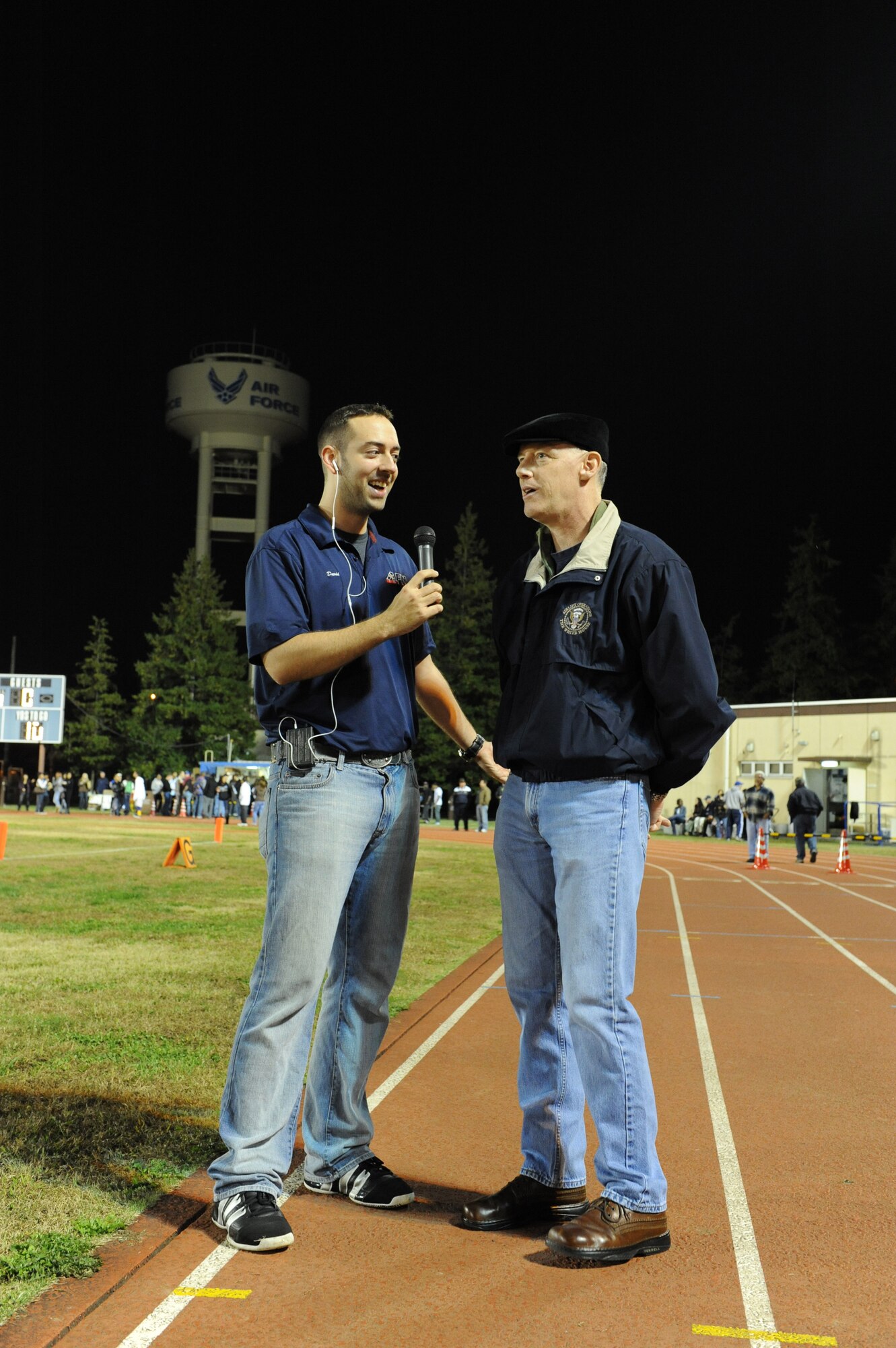 YOKOTA AIR BASE, Japan -- Col. Otto Feather, 374th Airlift Wing commander speaks to Senior Airman David Meade with the Armed Forces Network during half time at the Far East Championship game here, November 12, 2011. AFN delivered live radio coverage of the game as the Yokota Panthers defeated the Kubasaki Dragons 34-6 to clinch the Far East Division One title. (U.S. Air Force photo/Capt. Raymond Geoffroy)
