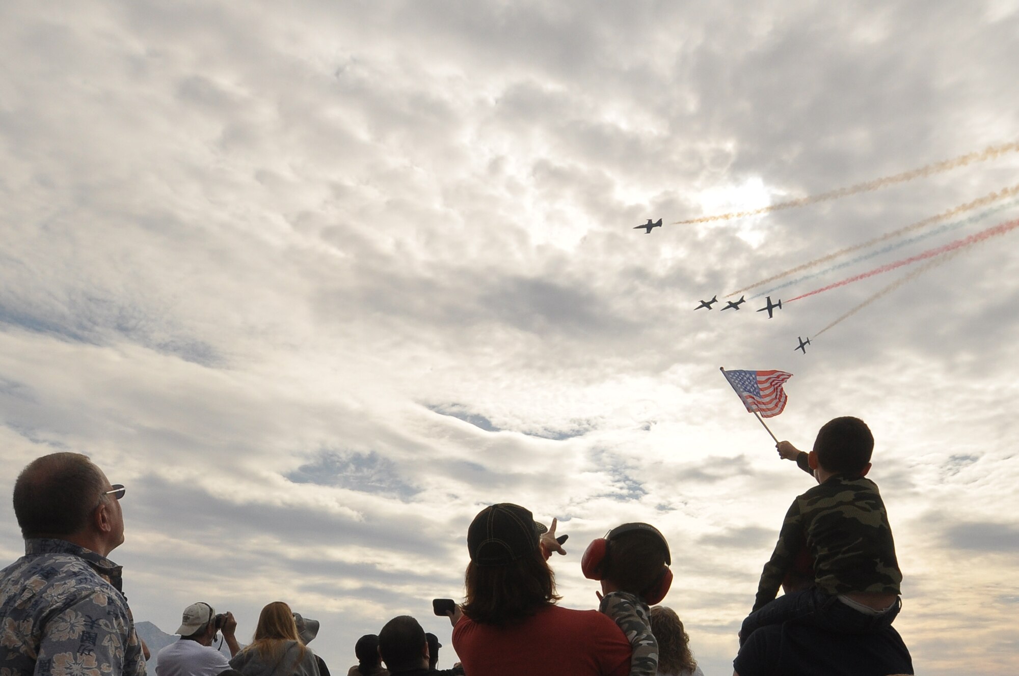 A boy holds an American Flag as spectators watch the sky as the Patriots Demonstration Team, fly overhead during the 2011 Aviation Nation Open House Nov. 13, at Nellis Air Force Base, Nev. Aviation Nation celebrates 70 years of airpower in Las Vegas and the Air Force's accomplishments in air, space and cyberspace. (U.S. Air Force photo by Tech. Sgt. Bob Sommer/Released)