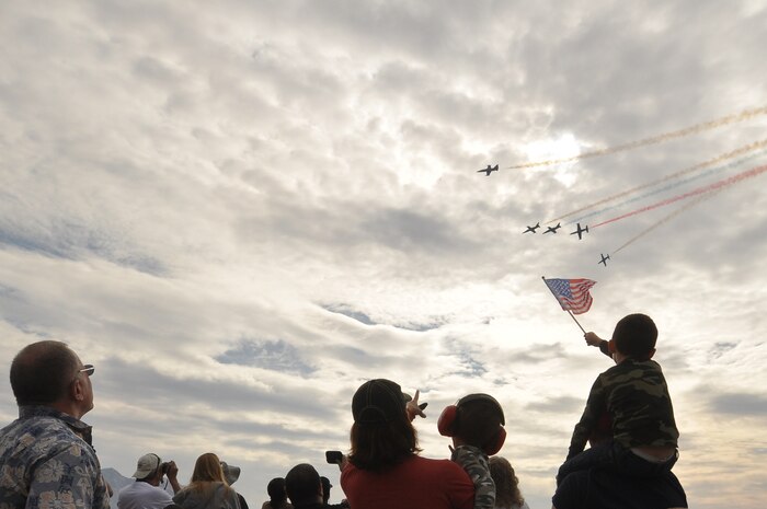 A boy holds an American Flag as spectators watch the sky as the Patriots Demonstration Team, fly overhead during the 2011 Aviation Nation Open House Nov. 13, at Nellis Air Force Base, Nev. Aviation Nation celebrates 70 years of airpower in Las Vegas and the Air Force's accomplishments in air, space and cyberspace. (U.S. Air Force photo by Tech. Sgt. Bob Sommer/Released)