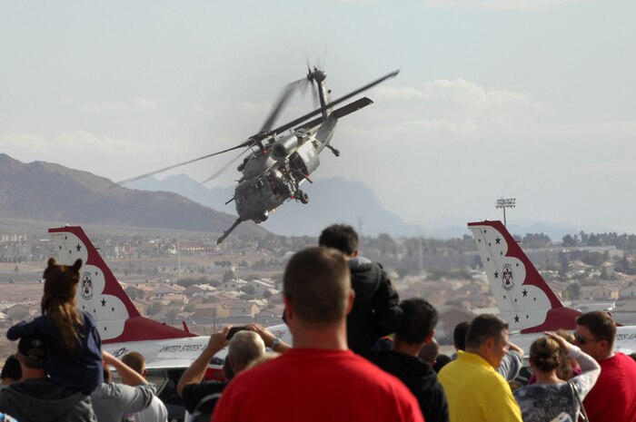 U.S. Air Force pararescueman fly in an HH-60 Pavehawk during a Present Day Air-to- Ground Mission Demonstration during the 2011 Aviation Nation Nov. 13th, at Nellis Air Force Base, Nev. Aviation Nation celebrates 70 years of airpower in Las Vegas and the Air Force's accomplishments in air, space and cyberspace. (U.S. Air Force photo by Staff Sgt. Taylor Worley/Released)