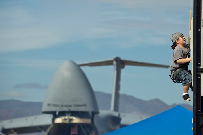 A boy climbs a rock wall during the 2011 Aviation Nation Open House Nov. 13, at Nellis Air Force Base, Nev. Aviation Nation celebrates 70 years of airpower in Las Vegas and the Air Force's accomplishments in air, space and cyberspace. (U.S. Air Force photo by Staff Sgt. Christopher Hubenthal/Released)