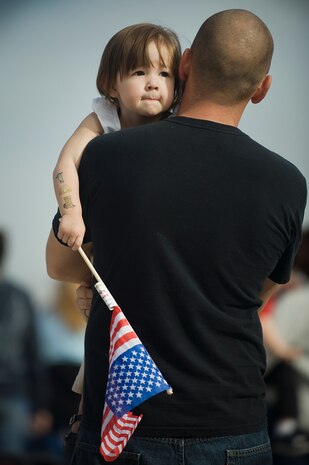 A girl holds an American Flag while watching the 2011 Aviation Nation Open House Nov. 13, at Nellis Air Force Base, Nev. Aviation Nation celebrates 70 years of airpower in Las Vegas and the Air Force's accomplishments in air, space and cyberspace. (U.S. Air Force photo by Staff Sgt. Christopher Hubenthal/Released)