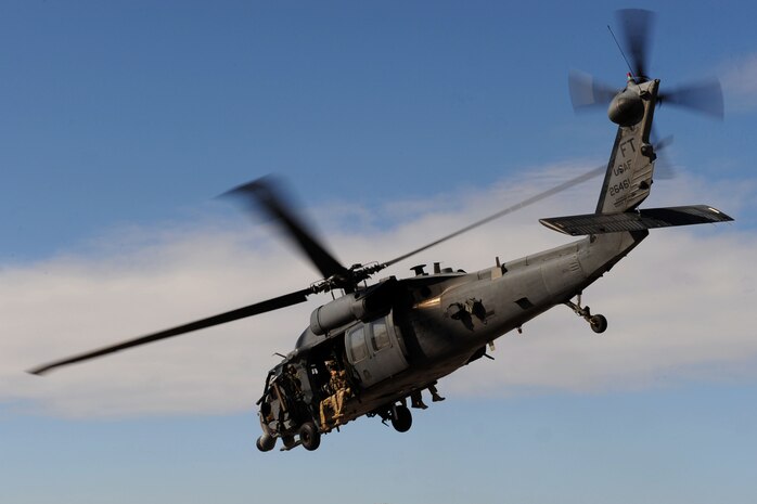 U.S. Air Force pararescueman fly in an HH-60 Pavehawk during a Present Day Air-to- Ground Mission Demonstration during the 2011 Aviation Nation Open House Nov. 12th, at Nellis Air Force Base, Nev.  Aviation Nation celebrates 70 years of airpower in Las Vegas and the Air Force's accomplishments in air, space and cyberspace. (U.S. Air Force photo by Staff Sgt. Taylor Worley/Released)