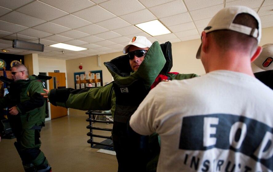 Lt. Col. Mark Krussow (middle) and Sgt. Maj. Patrick Standley, of the Army Explosive Ordnance Disposal Training Detachment, puts on the EOD bomb-suit to start the Veteran's Day Walk Nov. 11 at Eglin Air Force Base, Fla.  Army EOD techs took turns walking from Eglin to the EOD Memorial in the 79-pound bomb suit in two-person teams.  The detachment commander and sergeant major walked the first mile.  (U.S. Air Force photo/Samuel King Jr.)(U.S. Air Force photo/Samuel King Jr.)