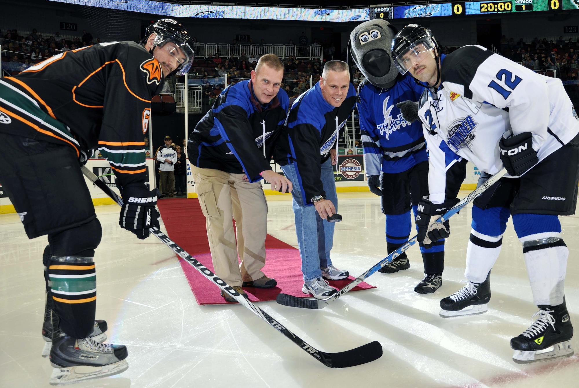 Col. William Mason, commander of the 931st Air Refueling Group, McConnell Air Force Base, Kan., and Col. Charles Carlton, commander of the 22nd Air Refueling Wing Medical Group, perform the ceremonial puck drop at the beginning of a Wichita Thunder hockey game on Veterans Day, Nov. 11, 2011.  The Wichita Thunder hockey team honored several Airmen from McConnell Air Force Base throughout the evening as part of a Veterans Day tribute.  (U.S. Air Force photo by 1st Lt. Zach Anderson)