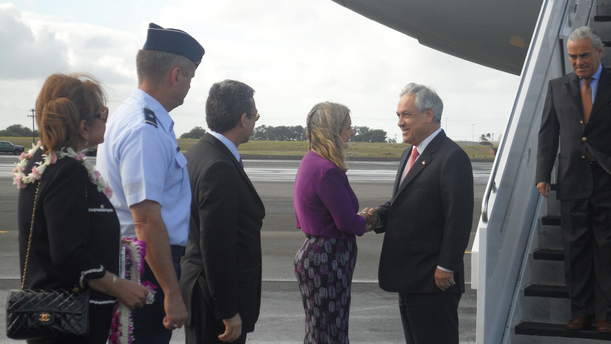 Gladys Boluda, U.S. State Department Assistant Chief of Protocol, greets Chile's President Sebastian Pinera upon his arrival at Joint Base Pearl Harbor-Hickam, for the Asia-Pacific Economic Cooperation summit, Nov. 11.  APEC economies account for 54 percent of global gross domestic product, 44 percent of world trade, and 61 percent of U.S. goods exports. (U.S. Air Force photo/Maj. Alysia Harvey)
