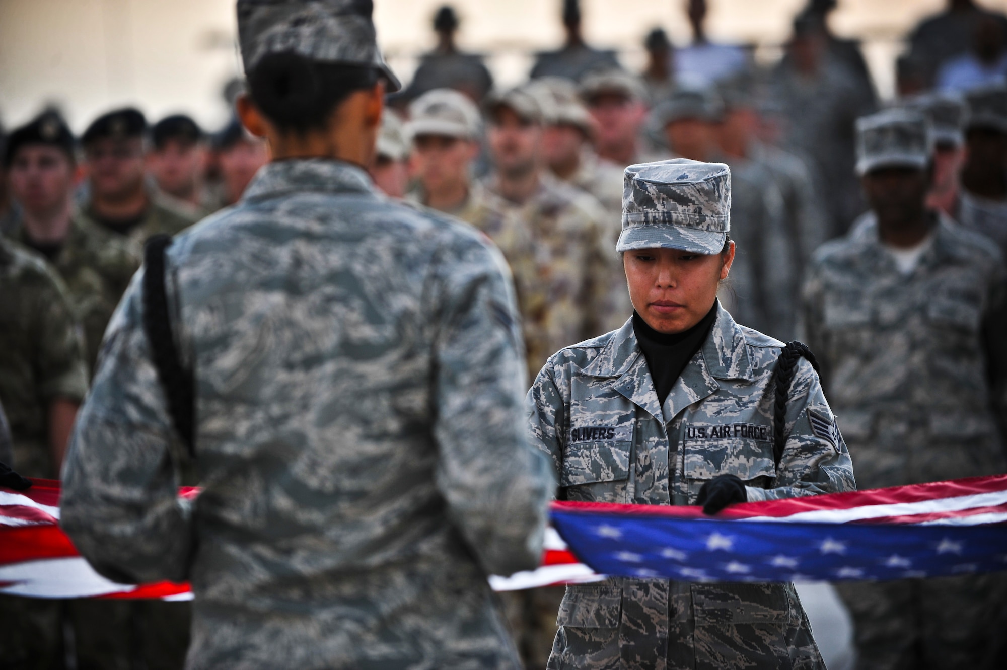 Staff Sgt. Dezarae Slivers, 379th Expeditionary Medical Group Bioenvironmental Engineering technician, helps fold the American flag during a Veterans Day ceremony Nov. 11, 2011, at an undisclosed location in Southwest Asia. Slivers, a native of Bear Springs, Ariz., is deployed from Kirtland Air Force Base, N.M. (U.S. Air Force photo/Senior Airman Paul Labbe)