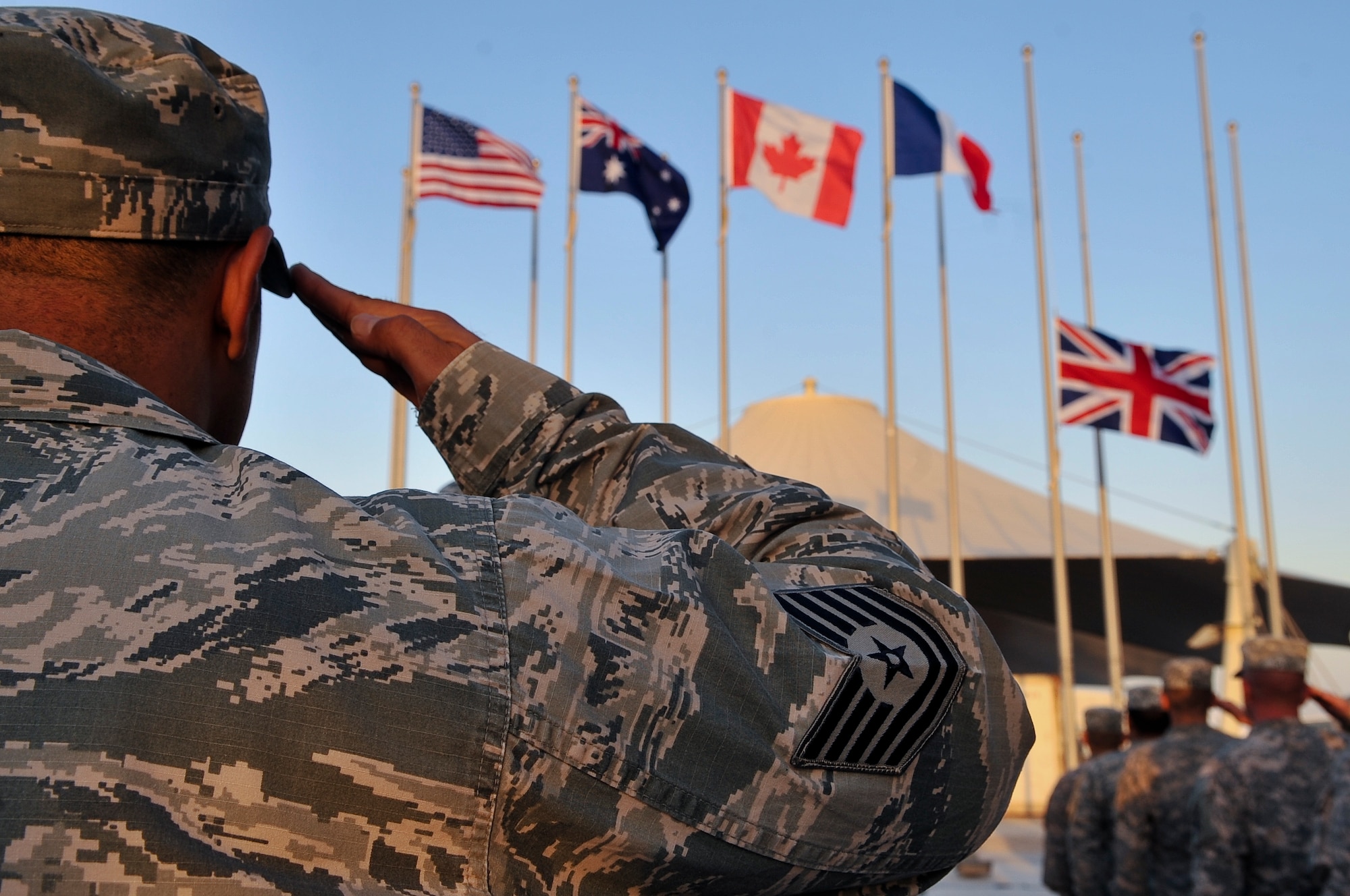 An Airmen from the 379th Air Expeditionary Wing salutes during the playing of coalition national anthems during a Veterans Day ceremony Nov. 11, 2011, at an undisclosed location in Southwest Asia. (U.S. Air Force photo/Senior Airman Paul Labbe)