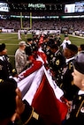 EAST RUTHERFORD, N.J. -- Marines wave back to a cheering crowd after a pregame ceremony before the  the New York Jets vs New England Patriots game, Nov. 13. The West Point Band performed at half time and 100 service members presented the large flag during the National Anthem. (Official Marine Corps photo by Cpl. Caleb Gomez / RELEASED)