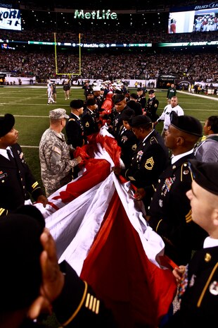 EAST RUTHERFORD, N.J. -- Marines wave back to a cheering crowd after a pregame ceremony before the  the New York Jets vs New England Patriots game, Nov. 13. The West Point Band performed at half time and 100 service members presented the large flag during the National Anthem. (Official Marine Corps photo by Cpl. Caleb Gomez / RELEASED)