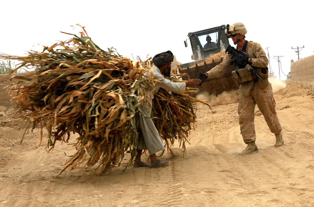Chief Warrant Officer 3 Brandon Smith, the officer in charge of Heavy Equipment Platoon, Support Company, 7th Engineer Support Battalion, 2nd Marine Logistics Group (Forward), shakes hands with a local elder during operations in Helmand province, Afghanistan, Nov. 3.  The Marines with 7th ESB repaired various points along Route 611 while working to improve relationships with locals.  (U.S. Marine Corps photo by Cpl. Katherine M. Solano)