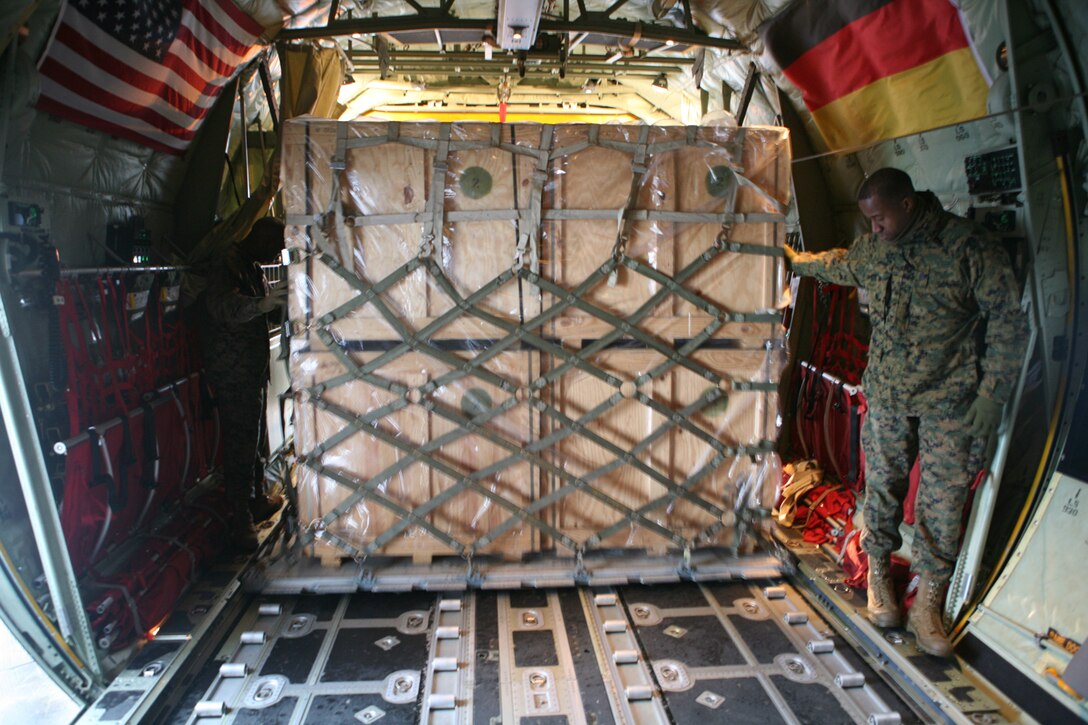 Gunnery Sgt. Wesley Key, Marine Forces Europe Strategic Mobility Chief, guides a pallet of cold-weather gear onto a C-130 at the Vaernes International Airport in Norway, Nov. 14. With assistance from Norwegian soldiers with the Marine Corps Prepositioning Program in Norway, the C-130 would later be filled with 110 cold weather tents, space heaters and fuel cans to be flown to Erzurum, Turkey, to help provide shelter and warmth to more than 1,000 Turkish citizens left homeless by recent earthquakes. Key is from Springfield, Ky.::r::::n::::r::::n::::r::::n::