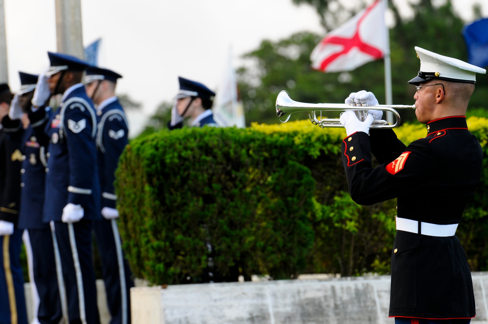 U.S. Honor Guardsmen from each branch of service on Okinawa render a salute while U.S. Marine Corps Cpl. Carlos Hernandez, III Marine Expeditionary Force Band bugler, plays "Taps" in the closing of the Veterans Day ceremony on Kadena Air Base, Japan, Nov. 11, 2011. During the ceremony, members from each branch of service on Okinawa came together to recognize the sacrifices made by all U.S. veterans, past and present. (U.S. Air Force photo/Airman 1st Class Maeson L. Elleman/released)
