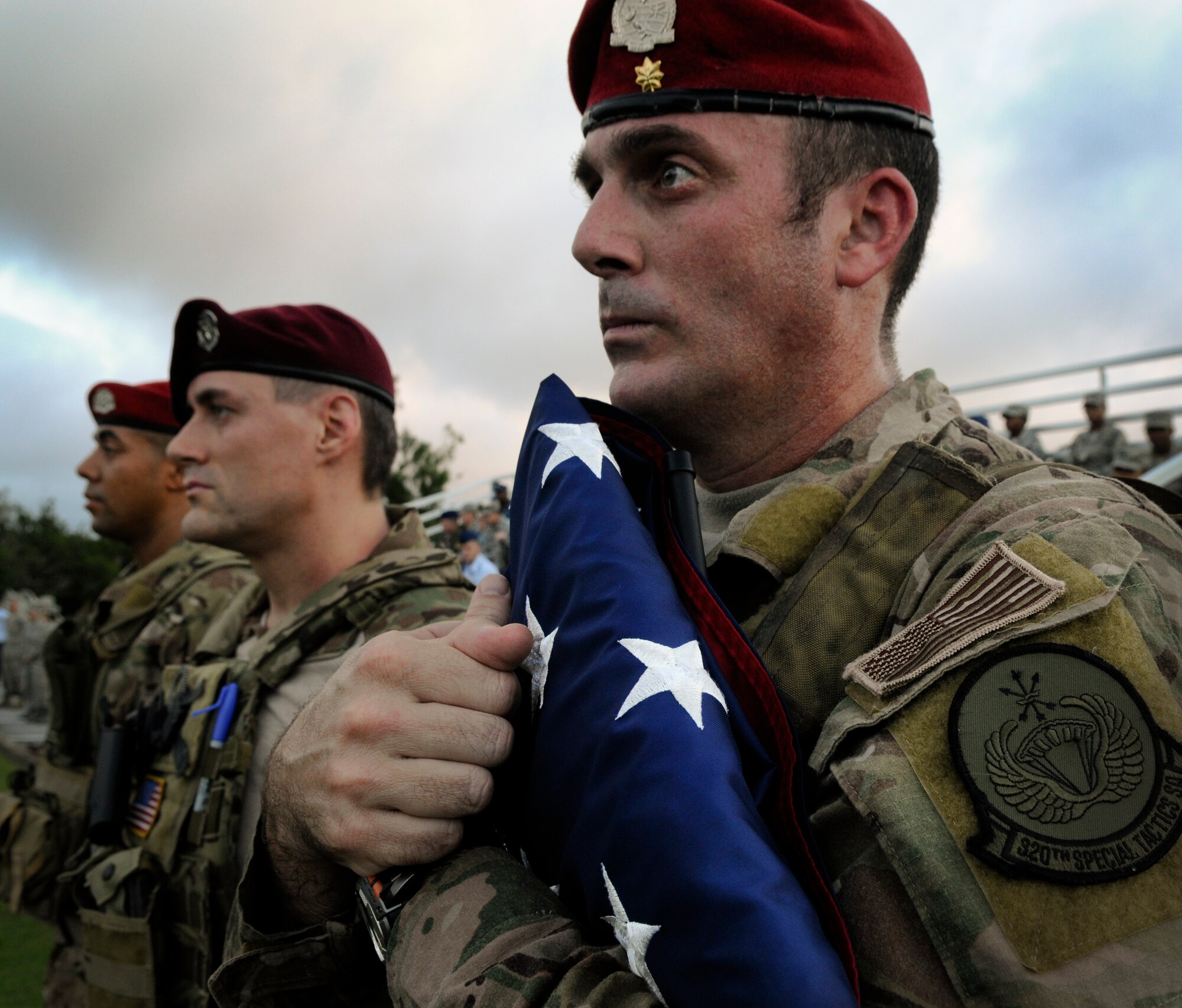U.S. Air Force Maj. John Traxler, 320th Special Tactics Squadron commander, carries the American flag before "Reveille" during the Veterans Day ceremony. Following the raising of the flag and the Japanese and American national anthems, four representatives from the services recited their branch's creed and guest speakers shared their experiences with the crowd. (U.S. Air Force photo/Airman 1st Class Maeson L. Elleman/released)