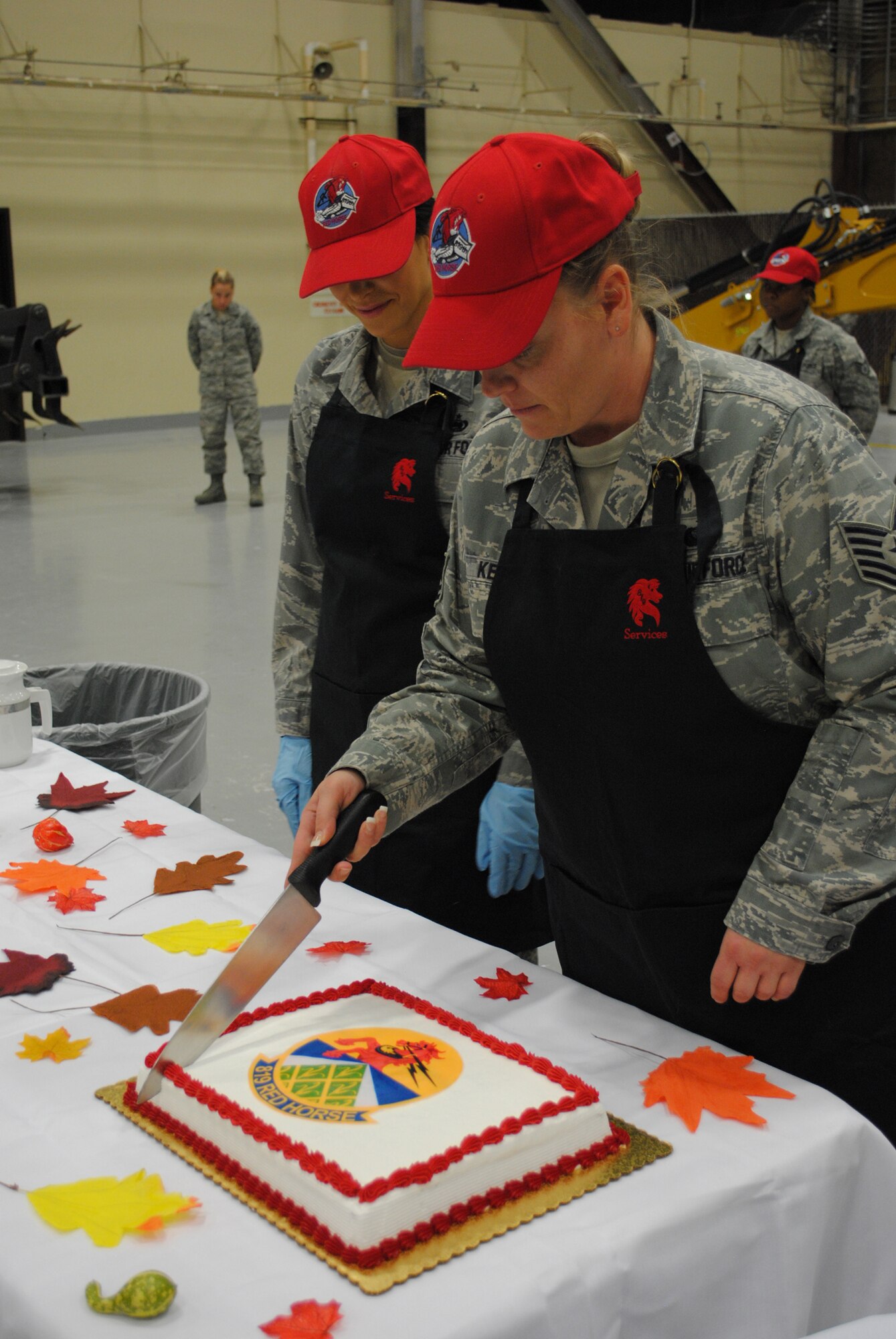 Tech. Sgt. Kellie Kemp, 819th RED HORSE Squadron NCO in charge of services readiness and plans, cuts the 819th RHS cake while Staff Sgt. Cara Crump, 819th RHS supply craftsman, stands by to place the pieces on the table. A luncheon was part of the CIVAIRES orientation tour Nov. 1. (U.S. Air Force photo/Airman Cortney Paxton)