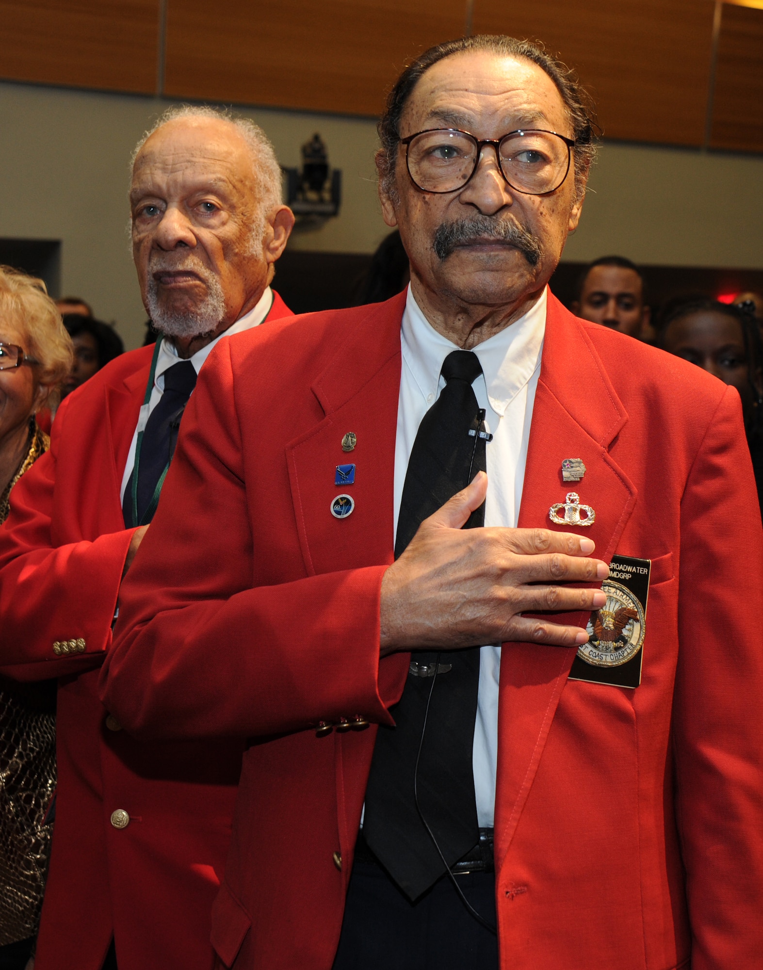 Left to right; Tuskegee Airmen Lemuel A. Lewie Jr. and William Broadwater pay respect to the U.S. flag during the national anthem Nov. 10, Pentagon auditorium, Arlington, Va. Lewie and Broadwater were distinguished guests during a special premier of “Double Victory,” an account of the Tuskegee Airmen’s struggles against fascism and racism during World War II. (U.S. Air Force photo by Staff Sgt. Christopher Ruano)