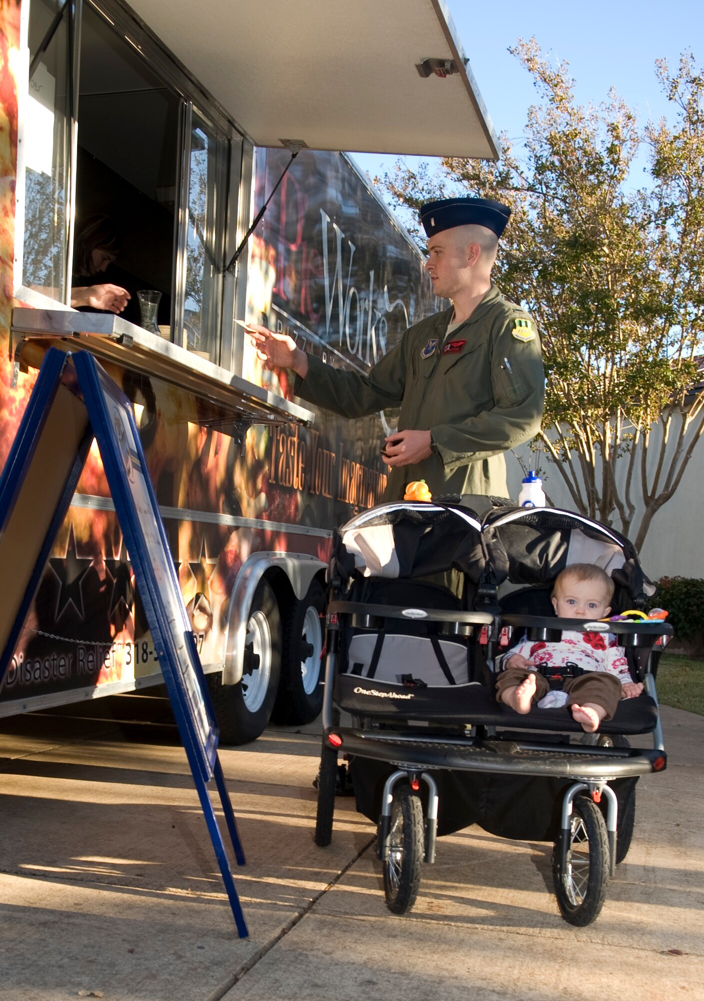 A Member of Team Barksdale pays for food at Hanger II during the First Friday event on Barksdale Air Force Base, La., Nov. 4. Every first Friday of the month Airmen and their families are able to celebrate the beginning of the new month in order to build morale. (U.S. Air Force photo/Airman 1st Class Benjamin Gonsier)(RELEASED)