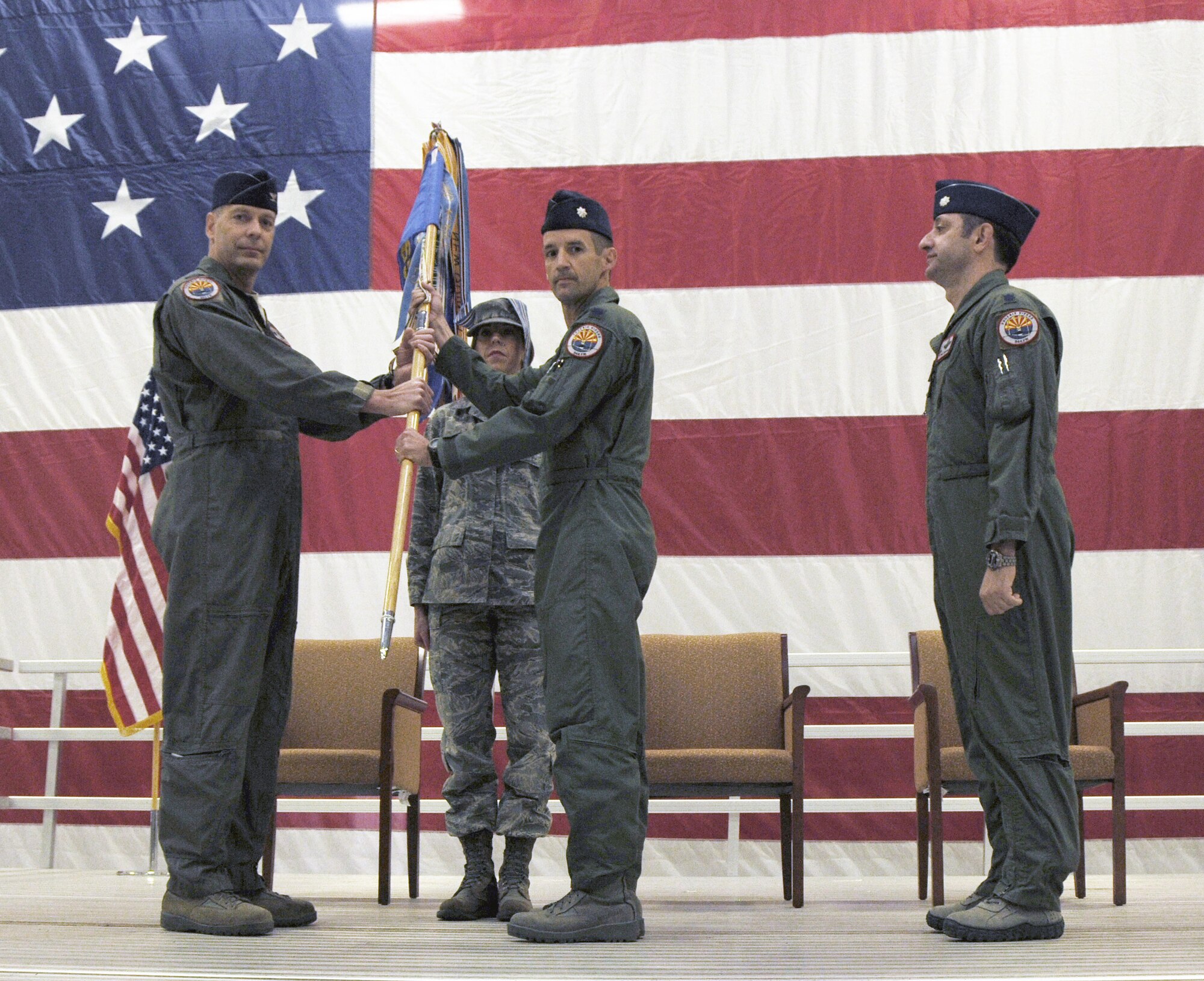 Lt. Col. David Garfield, 944th Operations Group commander, passes the guidon to Lt. Col. Bob Whitehouse November 4 as he assumes command of the 69th Fighter Squadron. Lt. Col. Miguel Torrealday relinquished command during the change-of-command ceremony. (U.S. Air Force photo/Capt. Elizabeth Magnusson) 