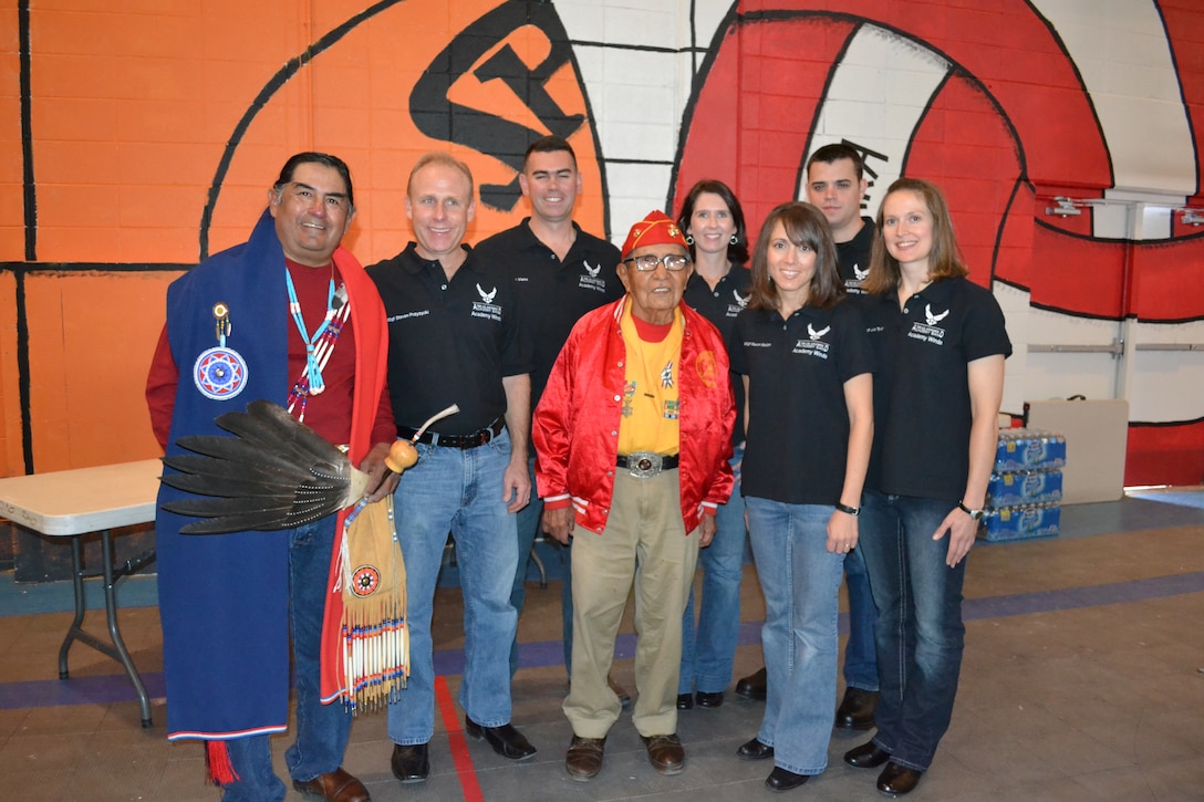 Academy Winds from the United States Air Force Academy poses with Navajo Code Talker Dave Patterson and Navajo tribal elder Michael Warren. Academy Winds participated in the Gourd Dance hosted at the Navajo Nation Reservation in Shiprock, NM, on Veterans Day to honor veterans from a number of Native American tribes, some from as far away as Oklahoma.