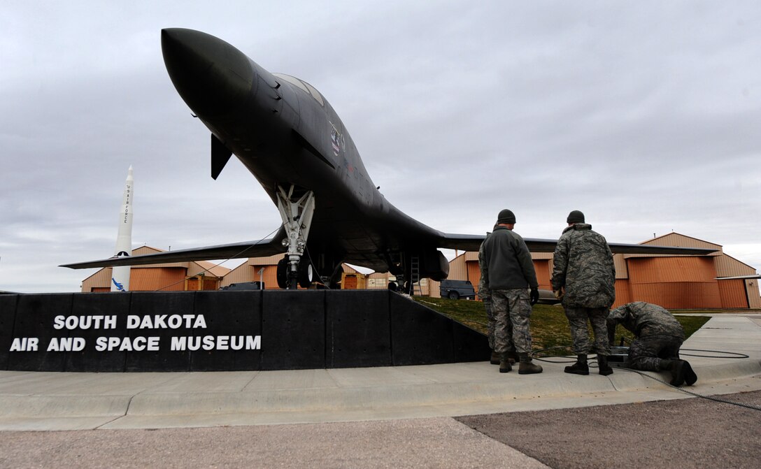 Airmen from the 28th Maintenance Squadron prepare to sweep the wings back on a static B-1 Lancer at the South Dakota Air and Space Museum in Box Elder, S.D., Nov. 1, 2011. The wings of the B-1 were swept back to a full flight configuration to present an aggressive look for museum visitors. (U.S. Air Force photo by Airman 1st Class Zachary Hada/Released)
