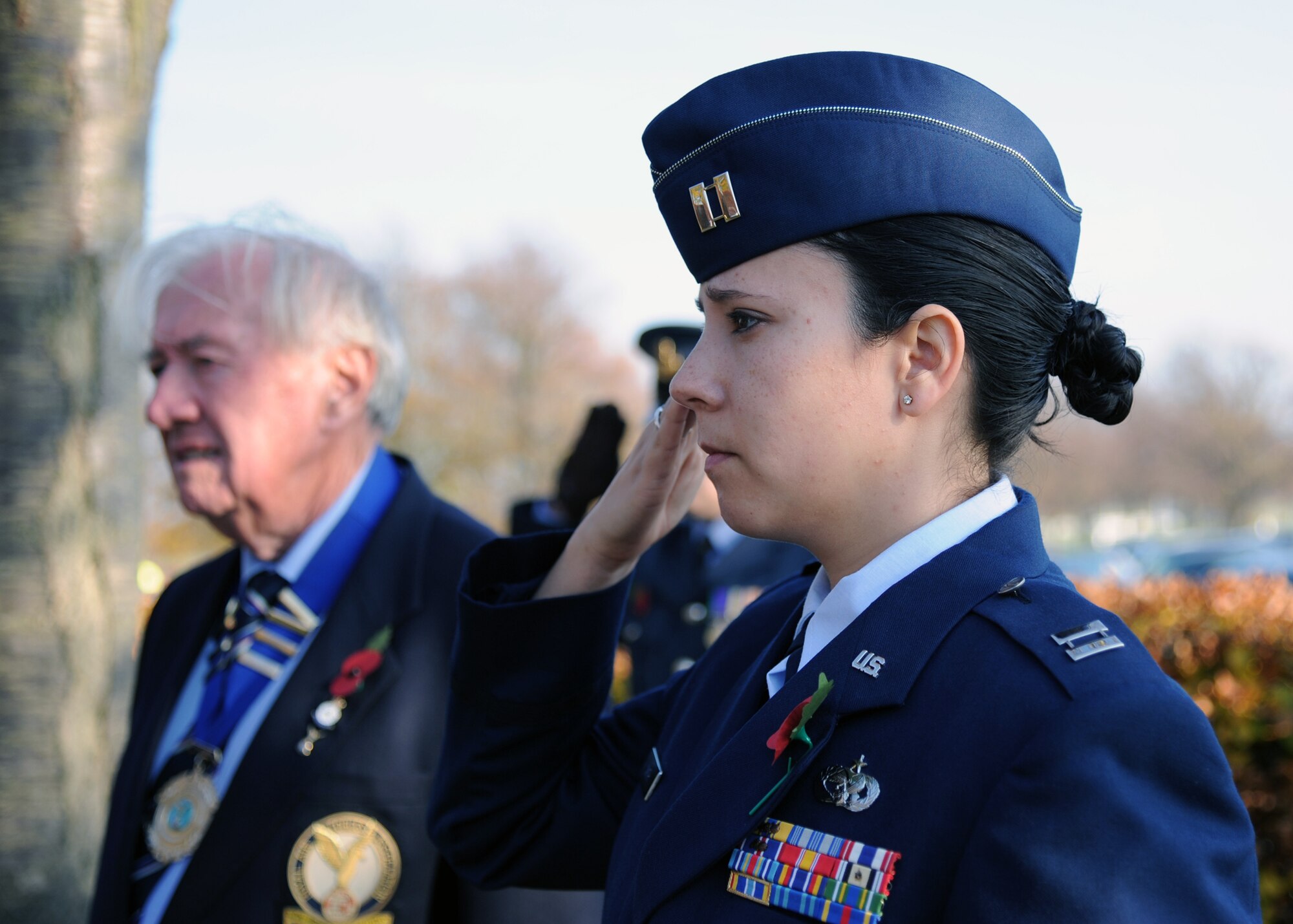 NEWMARKET, England – Capt. Katrina Smith, 727th Air Mobility Squadron operations officer, salutes as a bugle plays and the U.K. flag is lowered to the ground during a Remembrance Day ceremony at the Rowley Mile Racecourse in Newmarket Nov. 13, 2011. Smith, together with an RAF veteran of World War II and an RAF cadet, each laid a wreath at a memorial to the 99th Squadron, RAF, who were based in Newmarket from September 1939 to March 1941. (U.S. Air Force photo/Tech. Sgt. Kevin Wallace)