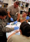 Air Force Reserve Maj. Darrell Surratt of the 919th Medical Squadron demonstrates a stitch for a simple suture on a lacerated pig’s foot at Duke Field, Fla., Nov. 6.  The 919th MDS conducted training on simple- interrupted sutures and mattress sutures using pigs’ feet during the November unit training assembly. (U.S. Air Force photo/Tech. Sgt. Cheryl L. Foster)
