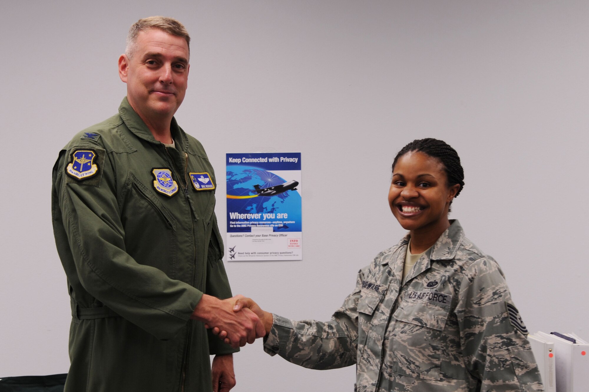 Col. Mike Minihan, 19th Airlift Wing commander, presents a commander’s coin to Tech. Sgt. Roxanne Boulware, 19th Communications Squadron non-commissioned officer in charge of base knowledge operations management, Nov. 7, 2011,  at Little Rock Air Force Base, Ark. Boulware, an Anchorage, Alaska, native, completely revamped the publications process which is now used Air Force wide, and is consistently requested by other base publishers offices. (U.S. Air Force photo by Airman 1st Class Kaylee Clark)