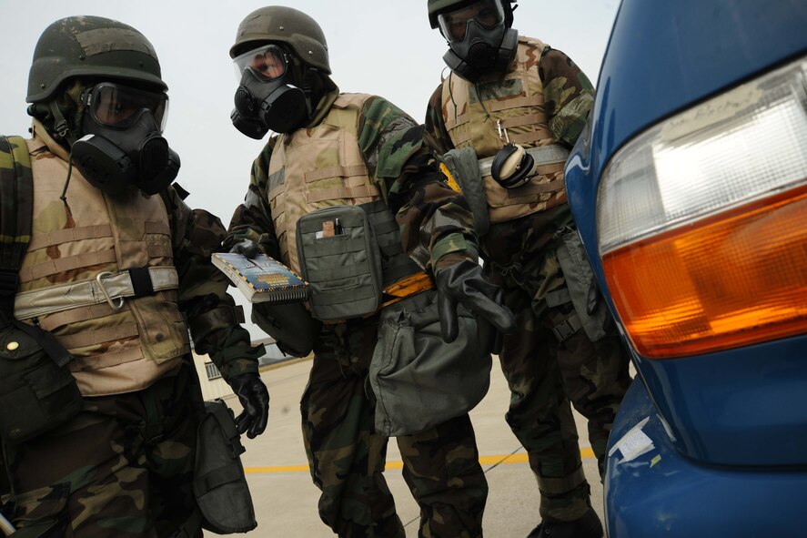 Airmen from the 8th Maintenance Group practice identifying chemical contaminants on simulated M-8 paper during an ability to survive and operate rodeo at Kunsan Air Base, Republic of Korea, Nov. 10. Airmen were evaluated in four man teams during 12 events, including transitioning from MOPP 0 to MOPP 4, self-aid buddy care, signs and counter signs, contaminated vehicles and stanchions. Each event was timed and graded as go-no on a 60 and 100 point scale. The team with the highest score and fastest time received a free pass. (U.S. Air Force photo by Senior Airman Brittany Y. Auld/Released)