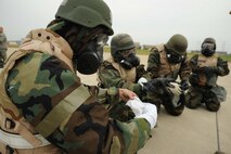 Members of the 8th Maintenance Group put on their MOPP 4 gear during an ability to survive and operate rodeo at Kunsan Air Base, Republic of Korea, Nov. 10. Airmen were evaluated in four man teams during 12 events, including transitioning from MOPP 0 to MOPP 4, self-aid buddy care, signs and counter signs, contaminated vehicles and stanchions. Each event was timed and graded as go-no on a 60 and 100 point scale. The team with the highest score and fastest time received a free pass. (U.S. Air Force photo by Senior Airman Brittany Y. Auld/Released)