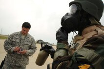 Staff Sgt. Ryan Merrigan, 8th Maintenance Group exercise evaluation team member, evaluates Airmen during an ability to survive and operate rodeo at Kunsan Air Base, Republic of Korea, Nov. 10. Airmen were evaluated in four man teams during 12 events, including transitioning from MOPP 0 to MOPP 4, self-aid buddy care, signs and counter signs, contaminated vehicles and stanchions. Each event was timed and graded as go-no on a 60 and 100 point scale. The team with the highest score and fastest time received a free pass. (U.S. Air Force photo by Senior Airman Brittany Y. Auld/Released)
