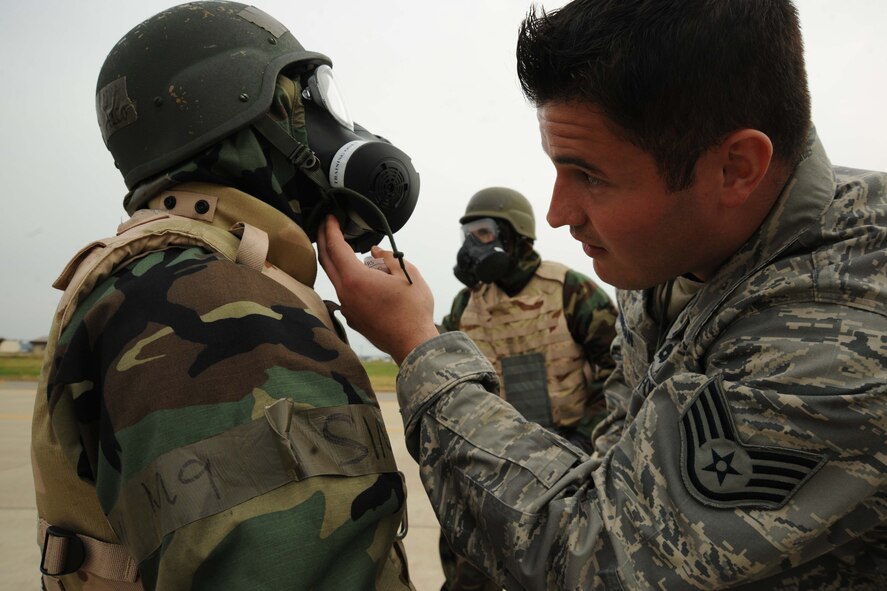 Staff Sgt. Ryan Merrigan, 8th Maintenance Group exercise evaluation team member, evaluates Airmen during an ability to survive and operate rodeo at Kunsan Air Base, Republic of Korea, Nov. 10. Airmen were evaluated in four man teams during 12 events, including transitioning from MOPP 0 to MOPP 4, self-aid buddy care, signs and counter signs, contaminated vehicles and stanchions. Each event was timed and graded as go-no on a 60 and 100 point scale. The team with the highest score and fastest time received a free pass. (U.S. Air Force photo by Senior Airman Brittany Y. Auld/Released)
