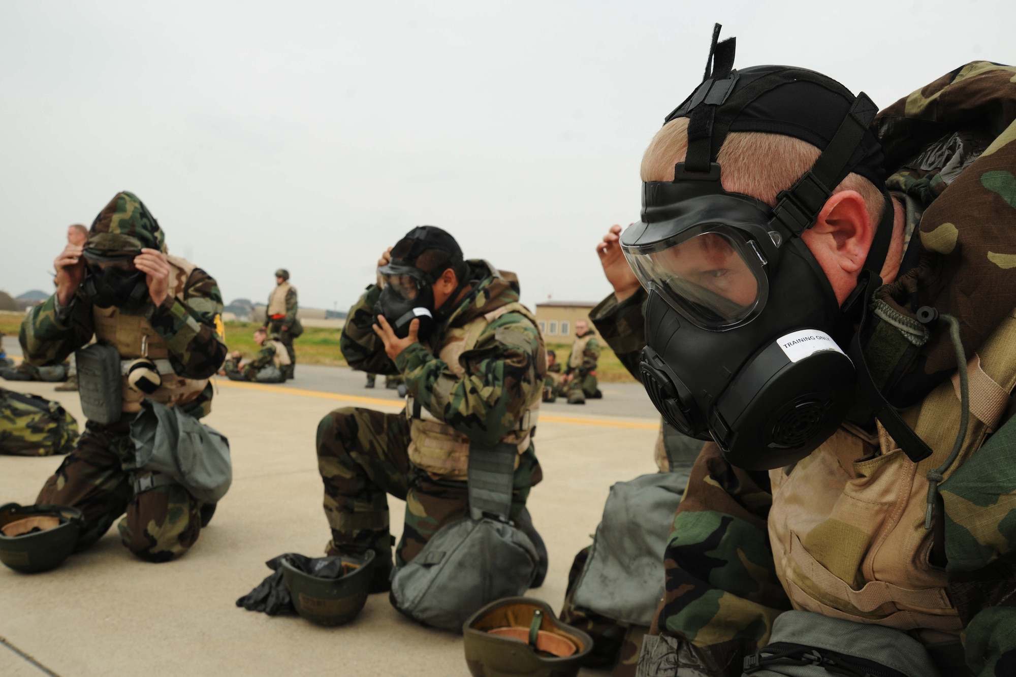 Members of the 8th Maintenance Group don their gas mask during an ability to survive and operate rodeo at Kunsan Air Base, Republic of Korea, Nov. 10. Airmen were evaluated in four man teams during 12 events, including transitioning from MOPP 0 to MOPP 4, self-aid buddy care, signs and counter signs, contaminated vehicles and stanchions. Each event was timed and graded as go-no on a 60 and 100 point scale. The team with the highest score and fastest time received a free pass. (U.S. Air Force photo by Senior Airman Brittany Y. Auld/Released)