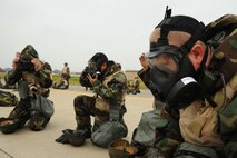Members of the 8th Maintenance Group don their gas mask during an ability to survive and operate rodeo at Kunsan Air Base, Republic of Korea, Nov. 10. Airmen were evaluated in four man teams during 12 events, including transitioning from MOPP 0 to MOPP 4, self-aid buddy care, signs and counter signs, contaminated vehicles and stanchions. Each event was timed and graded as go-no on a 60 and 100 point scale. The team with the highest score and fastest time received a free pass. (U.S. Air Force photo by Senior Airman Brittany Y. Auld/Released)