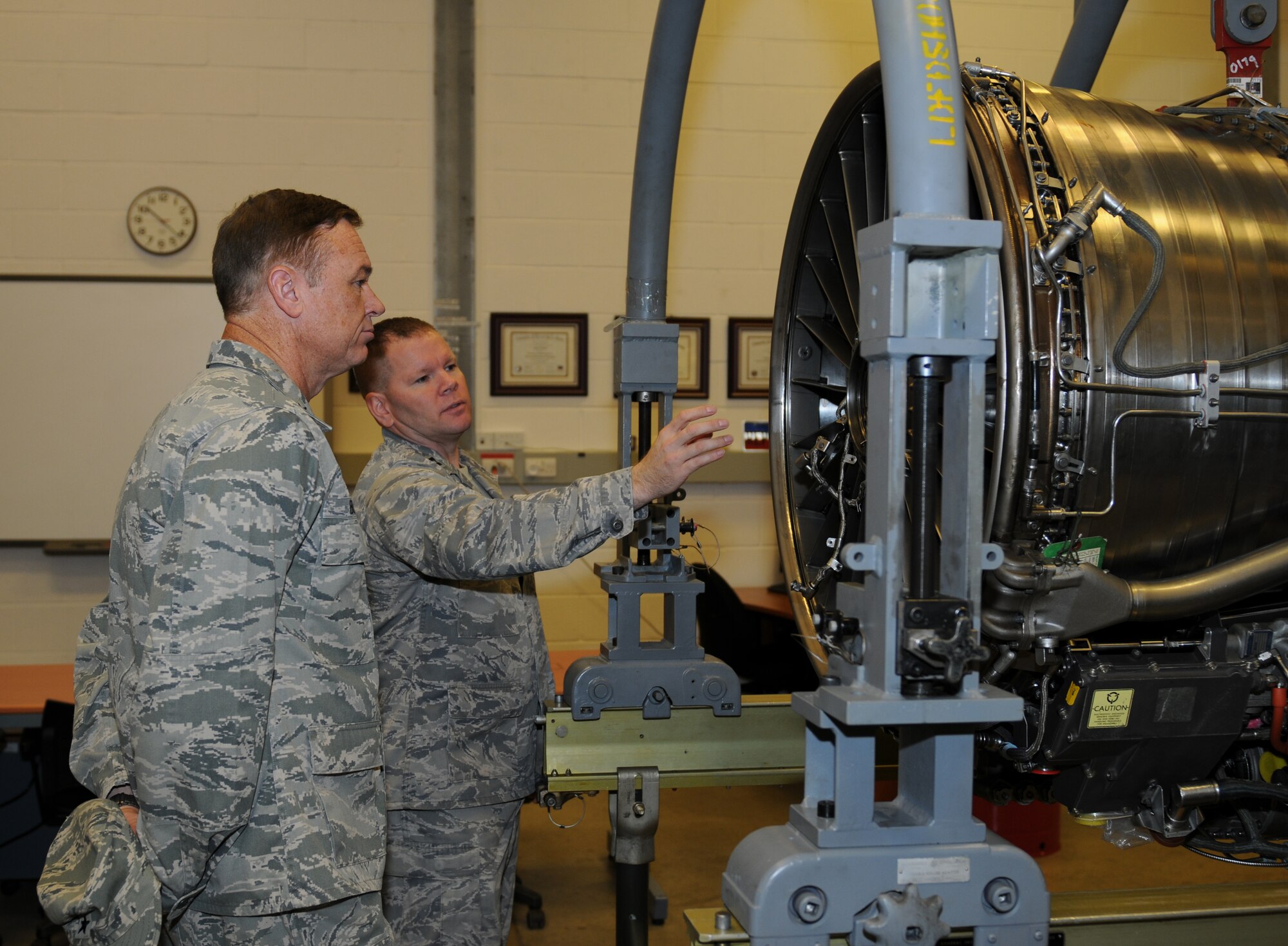 ROYAL AIR FORCE LAKENHEATH, England - Brig. Gen. Darryl W. Burke (left), 82nd Training Wing commander, and Capt. Scott Baker, 372nd Squadron Training Detachment 16 commander, discuss engine repairs and instruction during a visit, Nov. 10, 2011. The general toured the 372nd TRS Detachment 16 and was briefed by flight control, canopy, avionics and engine instructors.  (U.S. Air Force photo by Airman 1st Class Cory D. Payne)
