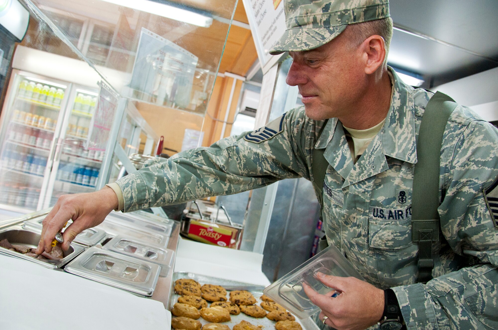 KANDAHAR AIRFIELD, Afghanistan -- Master Sgt. John Kortes, 451st Air Expeditionary Wing Public Health inspector, checks the temperature of the cold meats during a food facility’s monthly inspection at Kandahar Airfield’s boardwalk Nov. 14, 2011. Kortes inspects the food’s holding temperatures to ensure the food is safe for service members, civilians and contractors here. (U.S. Air Force photo by Senior Airman David Carbajal)