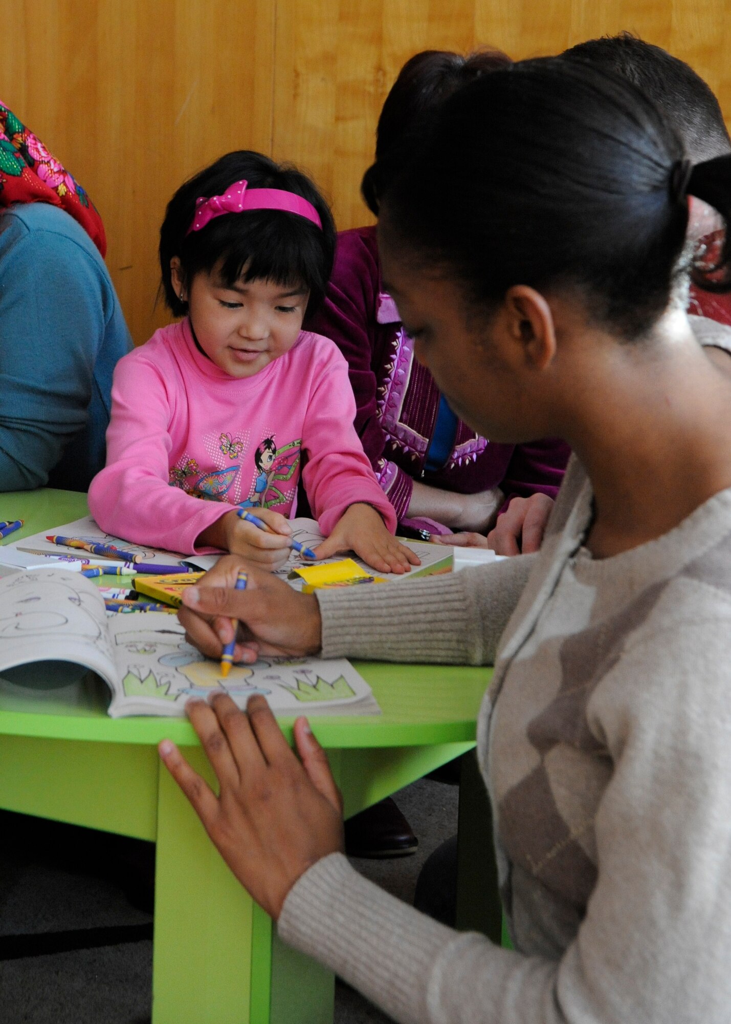 Staff Sgt. Michelle Fedrick colors with a Kyrgyz child at the Children's Heart Ward of the Kyrgyz Scientific Research Institute of Heart Surgery and Organ Transplantation in Bishkek, Kyrgyzstan, Nov. 11. The child is awaiting heart surgery. Fedrick is a member of the Manas Area Benefit Outreach Society, which MABOS helped replace windows in the heart ward and has donated funds for children’s surgeries. Fedrick is deployed to the Transit Center as an 817th Expeditionary Airlift Squadron aviation resource manager from Joint Base Lewis-McChord, Wash. (U.S. Air Force photo/Tech. Sgt. Tammie Moore)