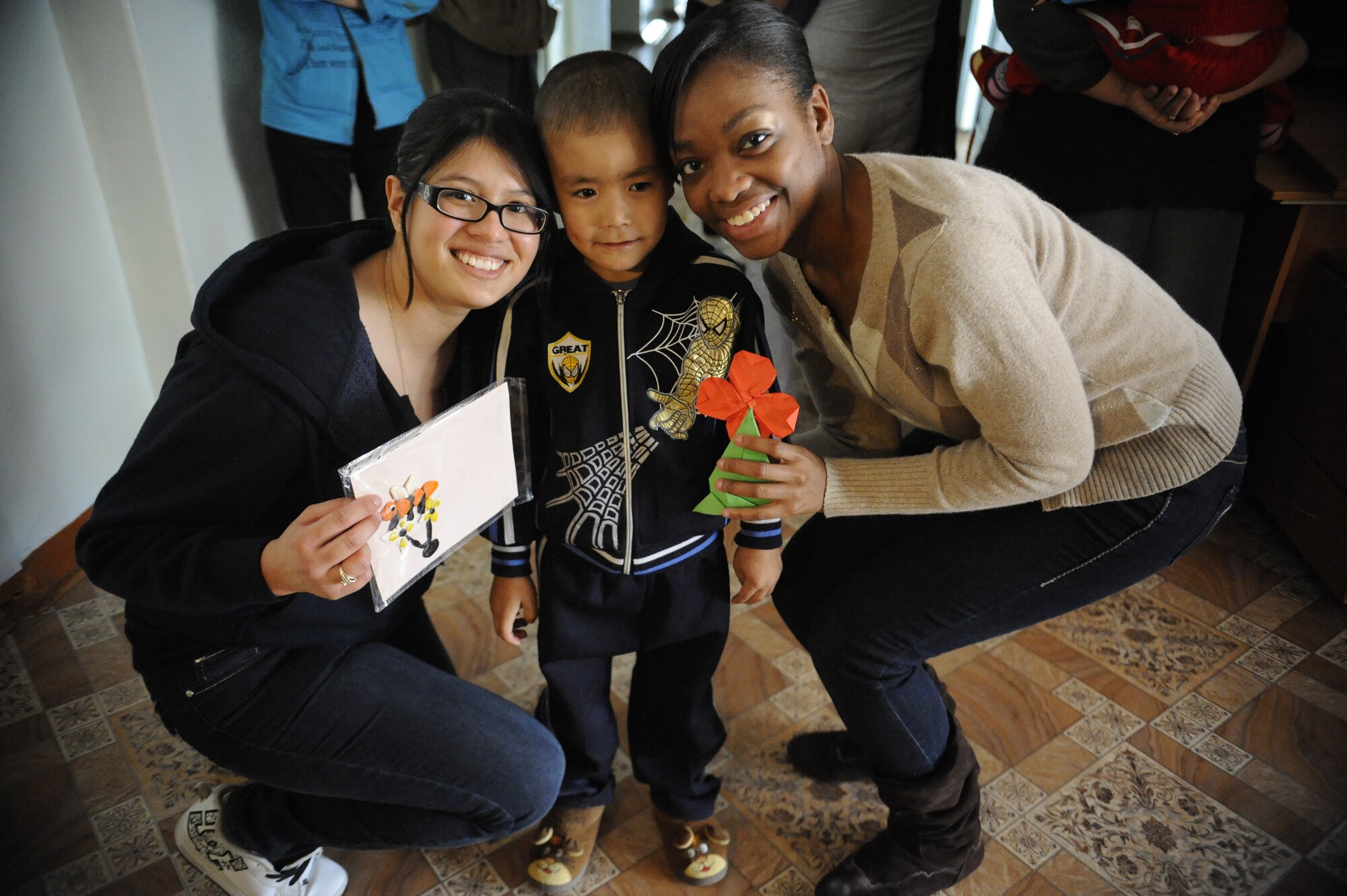 Airman 1st Class Juliana Guzman (left) and Staff Sgt. Michelle Fedrick pose for a photo with gifts from a Kyrgyz boy at the Children's Heart Ward of the Kyrgyz Scientific Research Institute of Heart Surgery and Organ Transplantation in Bishkek, Kyrgyzstan, Nov. 11. The Airmen are both members of the Manas Area Benefit Outreach Society. The MABOS members delivered toys to the children at the hospital and spent the day playing with them. Guzman is deployed to the Transit Center as a 376th Expeditionary Force Support Squadron quality assurance specialist from Air National Guard’s 146th Air Wing, Channel Islands , Calif. Fedrick is deployed to the Transit Center as an 817th Expeditionary Airlift Squadron aviation resource manager from Joint Base Lewis-McChord, Wash. (U.S. Air Force photo/Tech. Sgt. Tammie Moore)