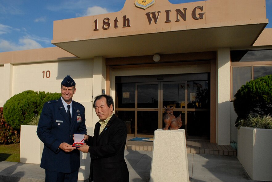 Col. Corey Martin, 18th Wing vice commander, presents a coin to Yasuo Ichikawa, Japanese Minister of Defense, after his visit to Kadena Air Base, Japan, Nov. 12, 2011. The minister's visit to Kadena was to discuss matters concerning the Okinawan people, the mission of the 18th Wing and to be shown first-hand the operations of Kadena during a tour of the flight line. (U.S. Air Force photo by Airman 1st Class Tara A. Williamson/released)