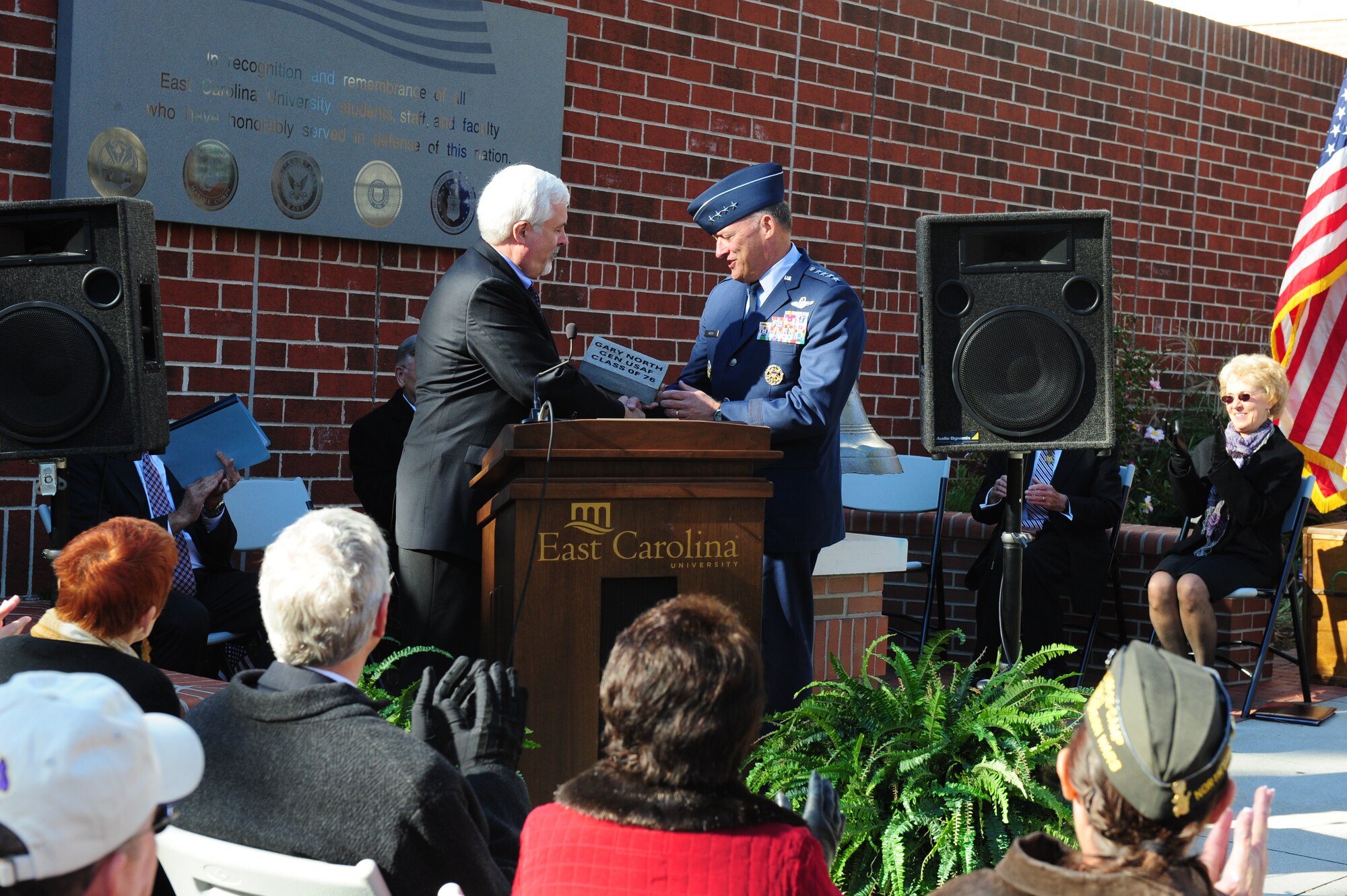 Mr. Rick Niswander, East Carolina University Vice Chancellor, presents a ceremonial paver to Gen. Gary North, Pacific Air Forces Commander, during a Veterans Day ceremony on the ECU campus in Greenville, N.C., Nov. 11, 2011.  North returned to his alma mater to speak to students and Reserve Officer Training Corps cadets and to participate in the university and town's Veterans Day ceremonies.  North was commissioned at ECU after graduating with a Bachelor's degree in political science in 1976.  (U.S. Air Force photo/Capt. Matt Schroff)