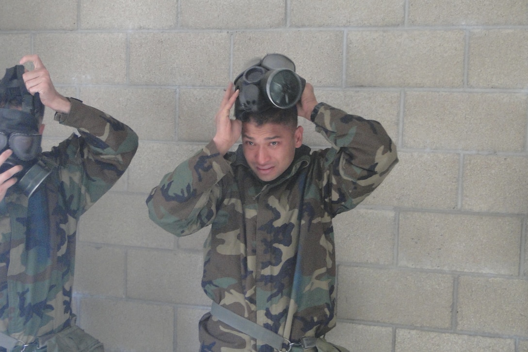 During the week evolution in the field, the students participate in many training exercises. While in the Confidence Chamber, a student anxiously awaits to place the M40 gas mask back onto his face, while CS gas fills the surrounding air.