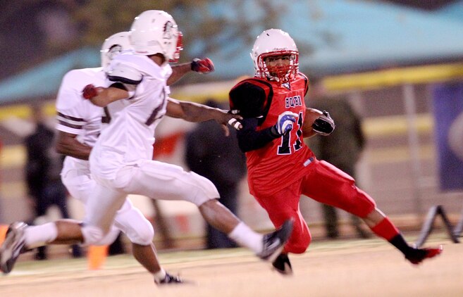 HQBN Bulldawg receiver, Mark Wood, rushes past the MCCES Mustangs defense for a first down during the Commanding General’s Intramural Football League championship game Nov. 15, 2011. The Bulldawgs fought hard for their undefeated season and brought that determination with them to the championship game.