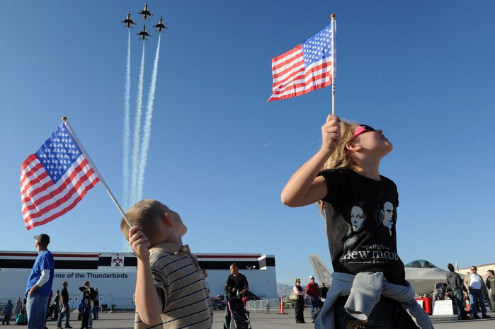 Young fans raise their American flags for the opening maneuver of the Thunderbirds' headlining performance Nov. 12 at "Aviation Nation 2011." As the U.S. Air Force's premier jet demonstration team, the Thunderbirds conclude their eight-month show season at the annual open house for Nellis Air Force Base, Nev., where the squadron is permanently stationed. (U.S. Air Force photo/Staff Sgt. Larry E. Reid Jr.)