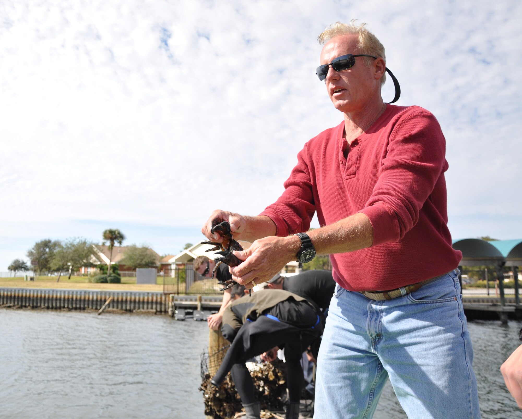 Mike Gray, water operations instructor at Air Force Special Operations Command Special Tactics Training Squadron, Hurlburt Field, Fla., releases a crab from a trap pulled from the Santa Rosa Sound. Gray led students from Air Force Special Operations Command Special Tactics Training Squadron, Hurlburt Field, Fla., in a cleanup of the Hurlburt Marina Nov. 12, 2011. Volunteers cleared the waterways of 3,700 pounds of debris.(U.S. Air Force photo/Rachel Arroyo) RELEASED