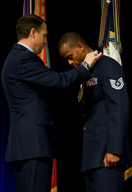 Maj. Gen. Earl Matthews, the director of Cyberspace Operations, presents Tech. Sgt. Leray Smedley, from Beale Air Force Base, Calif., the Spirit of Hope Award at the Pentagon on Nov. 15, 2011. Smedley received the award for volunteering more than 300 hours, raising $66,000, and leading 3,000 military and civilian personnel toward serving the Beale AFB and local communities in 70 events. (U.S. Air Force photo/Staff Sgt. Tiffany Trojca)