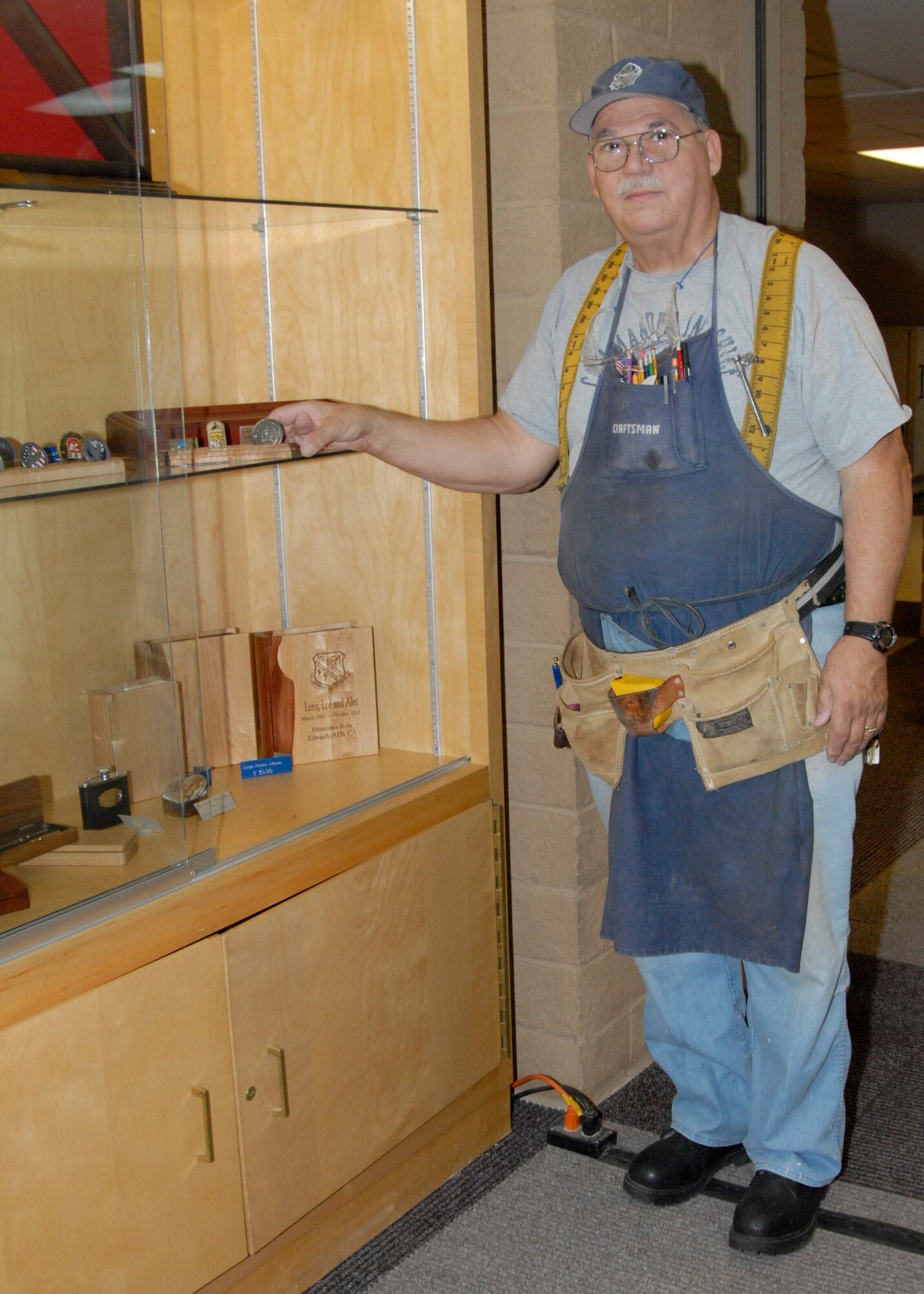 Chuck Hildebrand displays woodworking projects in the Arts and Crafts Center lobby. Tasked with overseeing the woodshop, Hildebrand also teaches the woodshop safety class and makes the rounds to assist with ongoing projects. (U.S. Air Force Photo by Laura Mowry)
