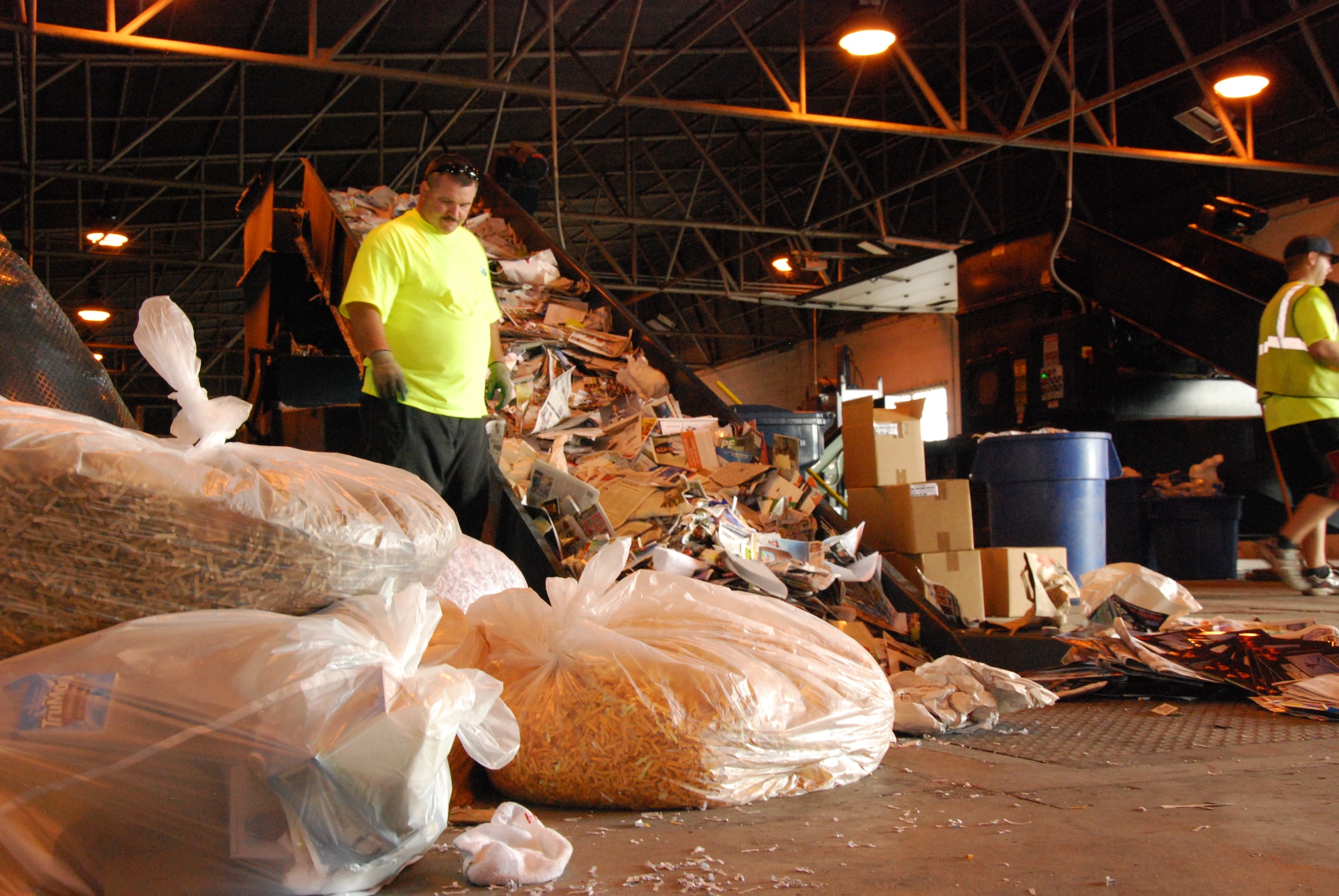 Sheppard Recycling Center workers load a machine Nov. 7, 2011, that will compact paper into bales, each weighing just shy of a ton. The recycling center at Building 2140 can take paper, plastics, cardboard, aluminum and tin cans, and scrap metal while the center at Building 2141 accepts fluorescent bulbs, paint and batteries. (U.S. Air Force photo/Capt. Brittany Martin)