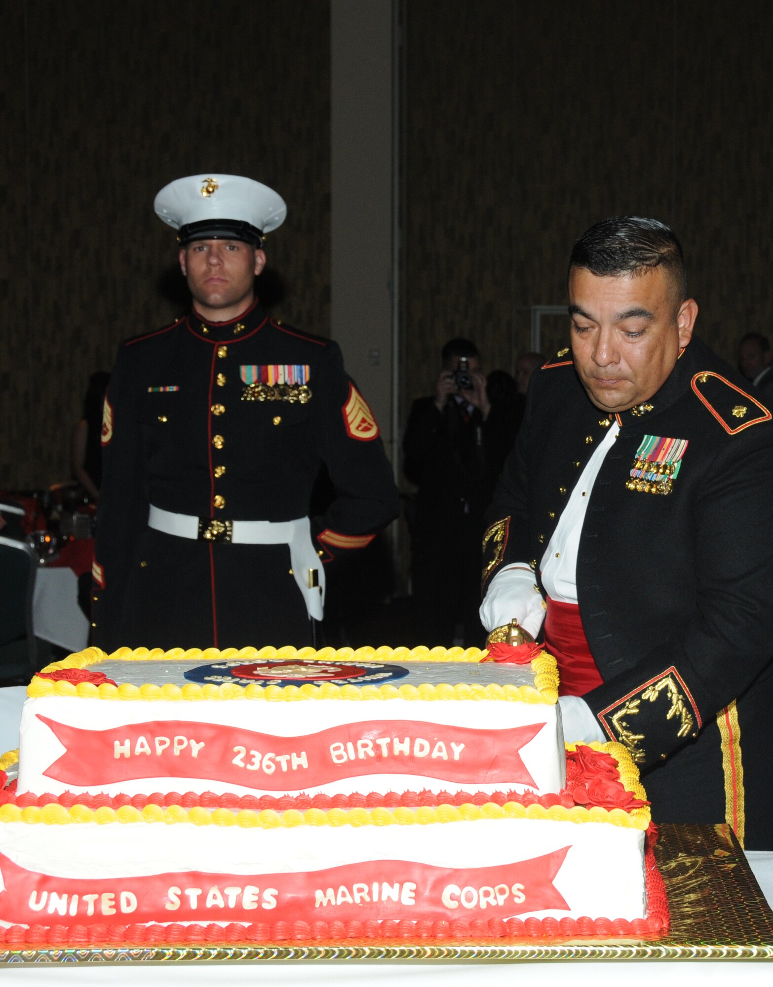 Maj. Nieves Villasenor, Keesler Marine Corps Detachment Commanding Officer, cuts the birthday cake using an NCO sword as Staff Sgt. Ryan Zak, MARDET, member of the sword escort detail, looks on during the Marine Corps Ball Nov. 10, 2011, at the Mississippi Coast Coliseum Convention Center in Biloxi, Miss.  (U.S. Air Force photo by Kemberly Groue)